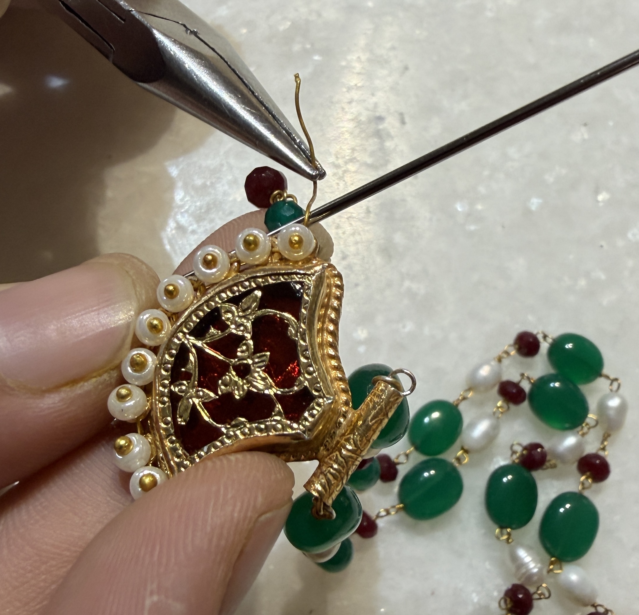 Close-up of hand finishing 23K gold Thewa jewellery work by Sonkanch, Jaipur